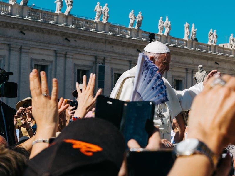 Pope Francis, surrounded by a crowd in St. Peter's square. The Pope must lead our approach to contemporary issues
