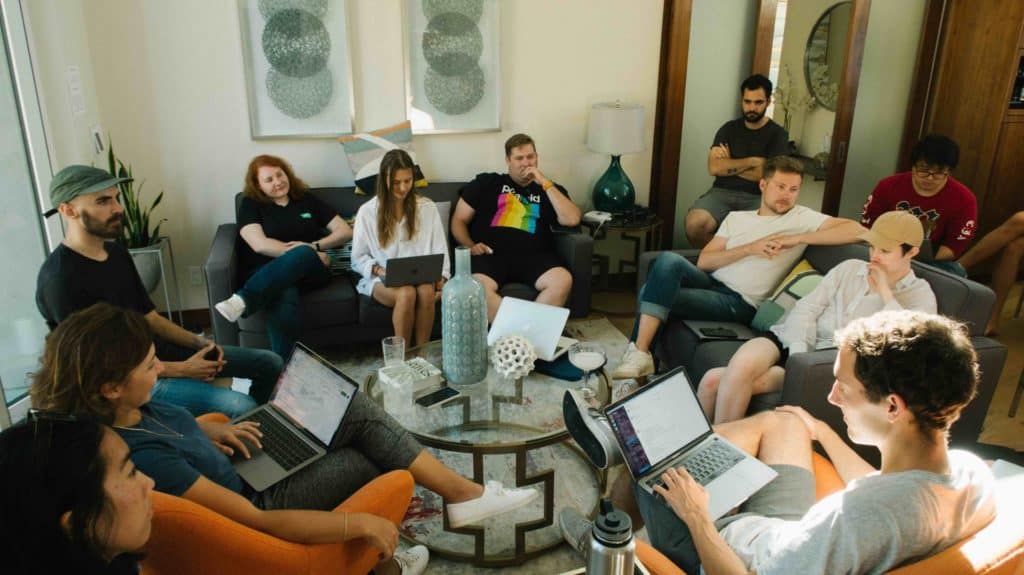 A group of people sitting on couches, holding a discussion, perhaps about climate change