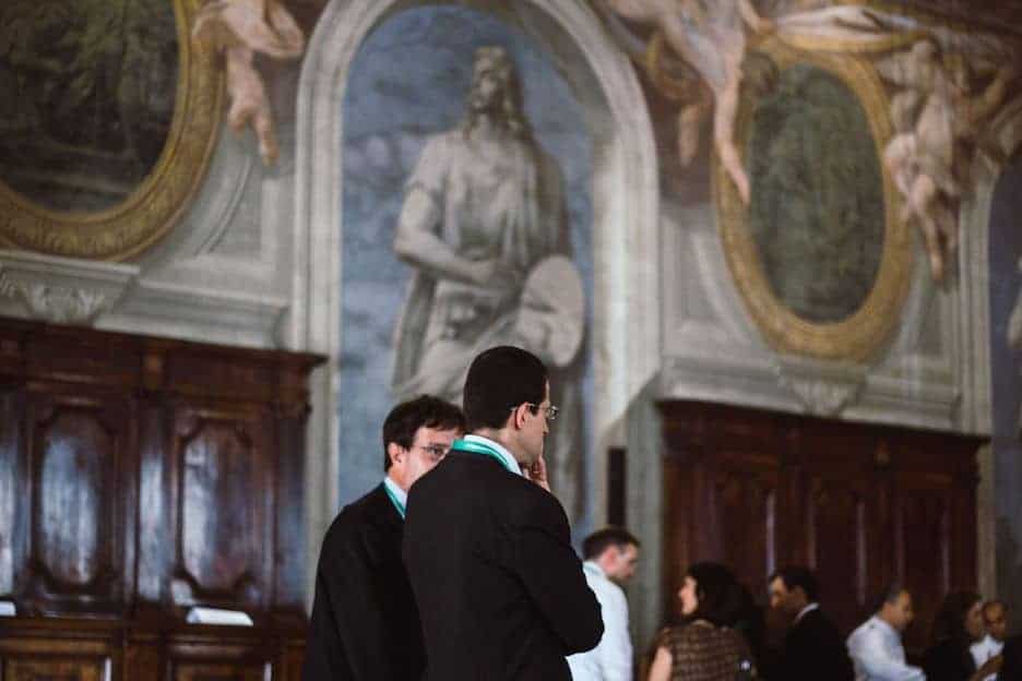Two men speak together at a conference at the Vatican, which is the main source for Catholic social teaching resources and articles