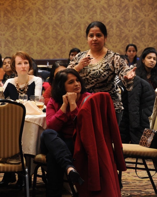 At a women's business dinner, a woman of color stands up to speak, showing our responsibility to stand up against racism in the United States