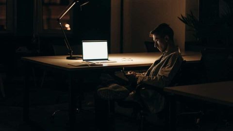 A man alone at night representing alienation, workaholics, and despair.