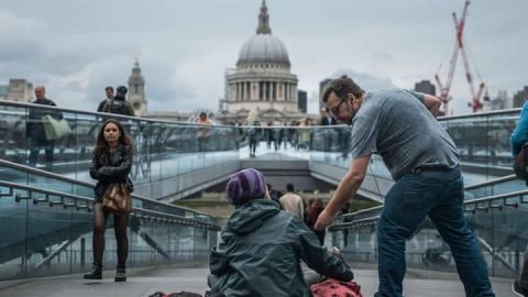 A man gives to a poor homeless person begging on the street.